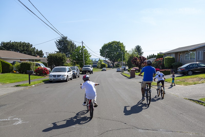 family biking on an open street
