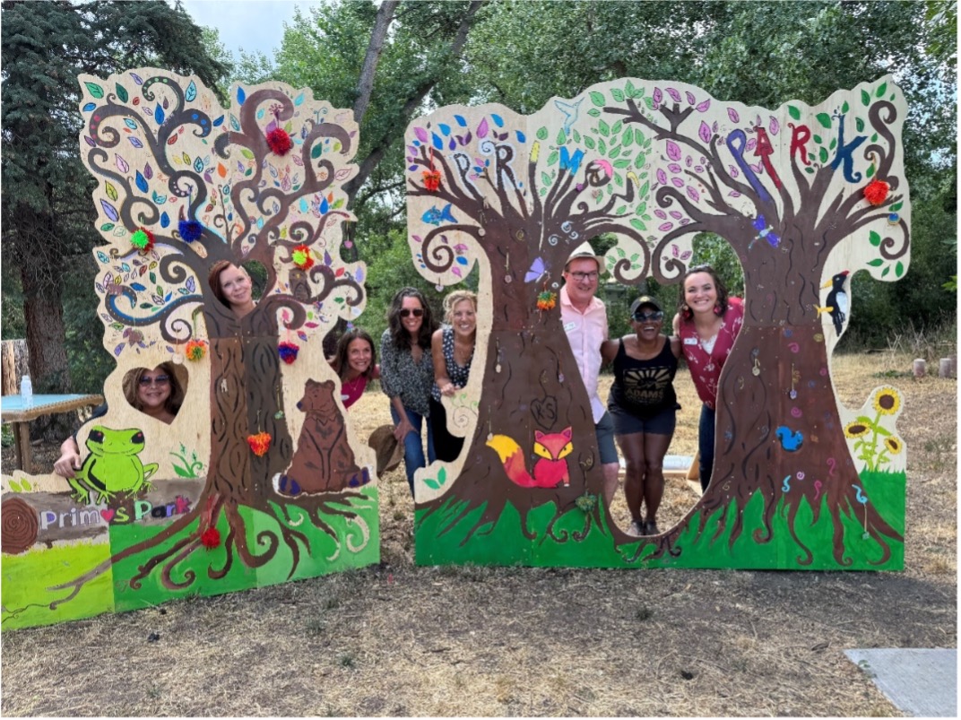 People stick their head into cut outs in wooden tree cut outs