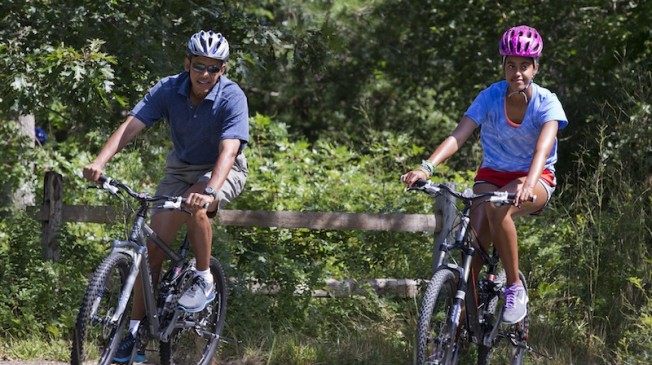 President Obama and the first family cycle together on vacation.  Credit: AP Photo/Jacquelyn Martin