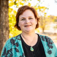 Woman with short hair smiling outside