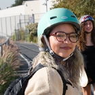 two girls in helmets on paved trail